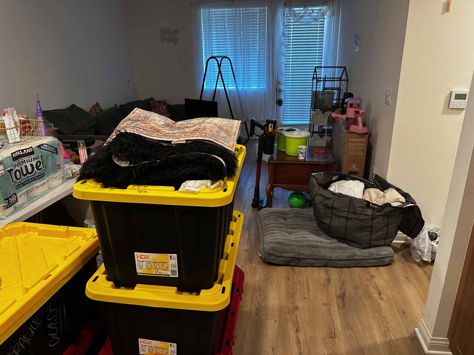 Living room full of totes, furniture, and household items before a Royce Professional Services cleanout